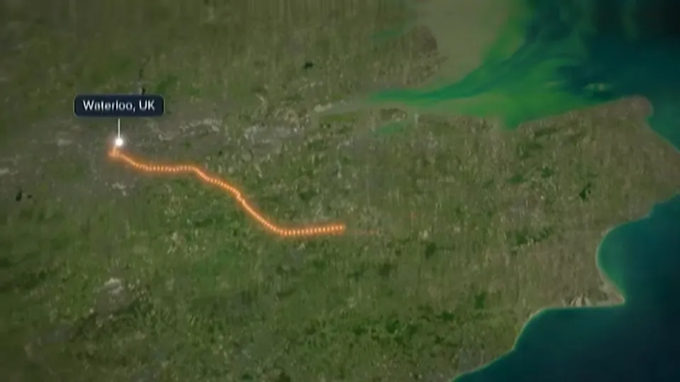 Un mapa satelital del sur de Inglaterra con una ruta naranja punteada que sale de Waterloo