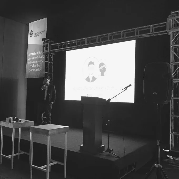 Ponente en el atril, con el escenario a media luz